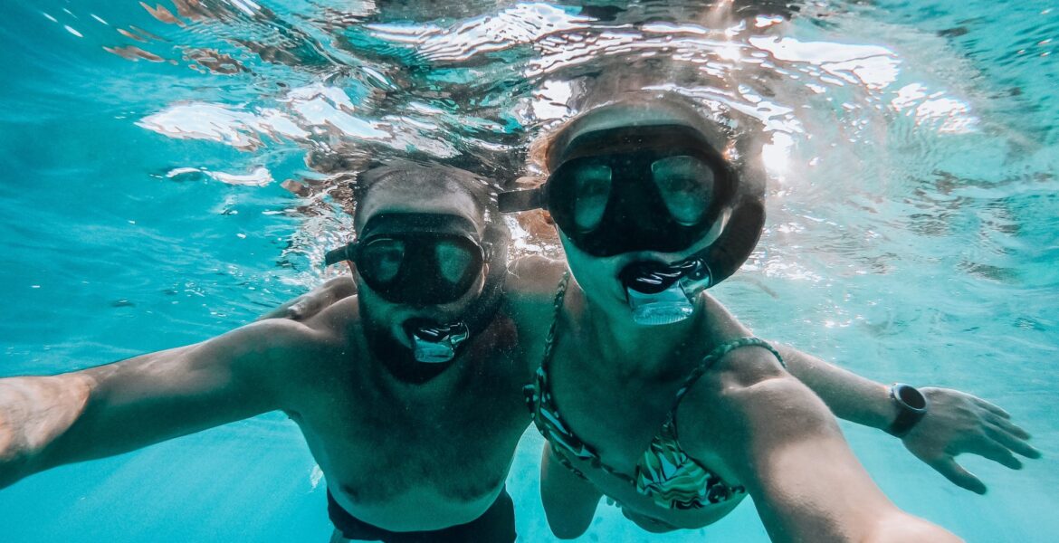 A couple diving while wearing diving equipment