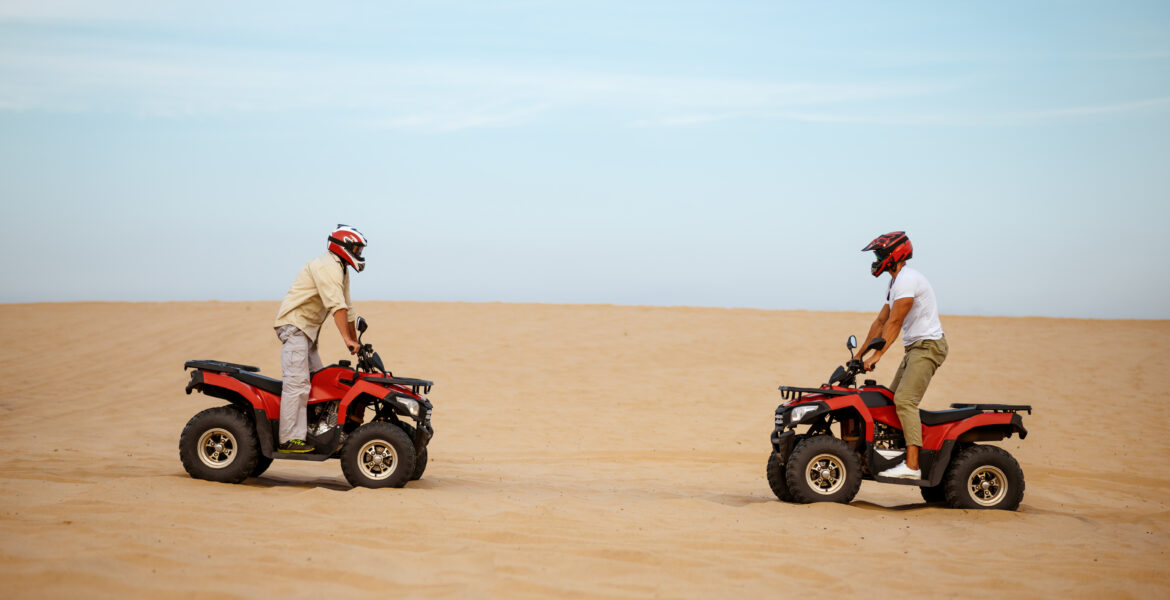 Two men, each driving a safari vehicle.
